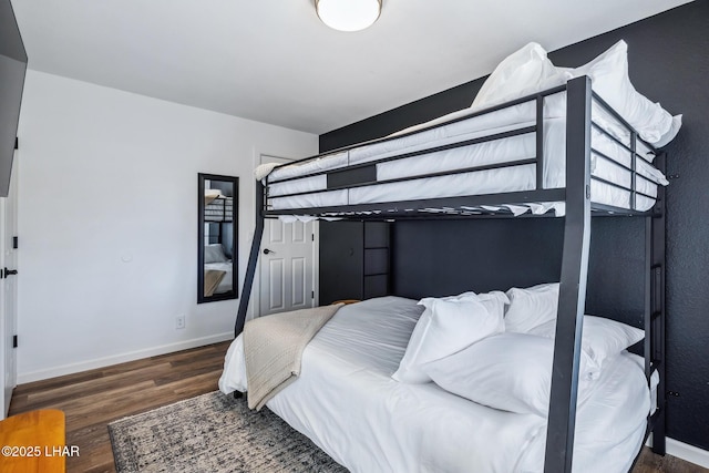bedroom featuring baseboards and wood finished floors