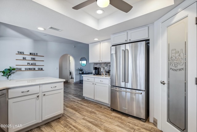 kitchen featuring stainless steel appliances, arched walkways, visible vents, ceiling fan, and light countertops