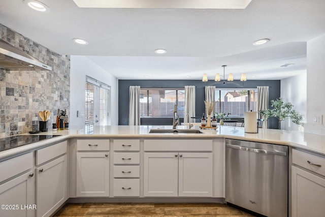 kitchen with stainless steel dishwasher, a sink, decorative backsplash, black electric stovetop, and a peninsula