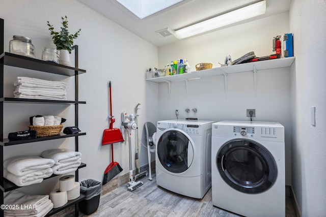 laundry area with light wood finished floors, laundry area, visible vents, baseboards, and washer and dryer
