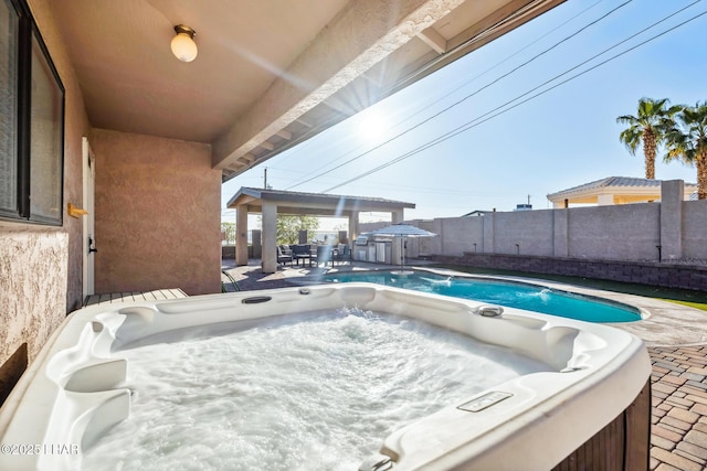 view of swimming pool with a fenced backyard, a hot tub, and a patio area