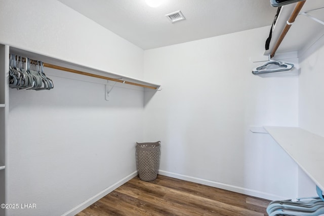 walk in closet featuring visible vents and wood finished floors