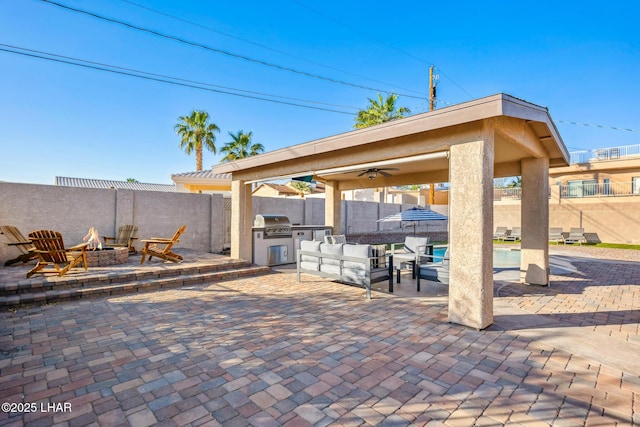 view of patio / terrace featuring a fire pit, area for grilling, exterior kitchen, and a fenced backyard