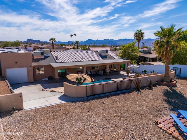 back of house featuring a mountain view, a garage, and a patio area