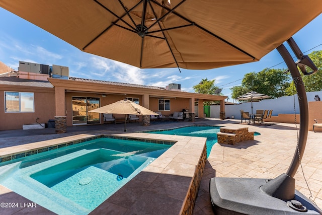 view of swimming pool featuring central AC, a patio, and an in ground hot tub