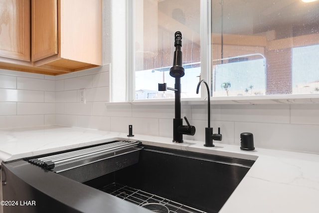 kitchen featuring light stone countertops and backsplash