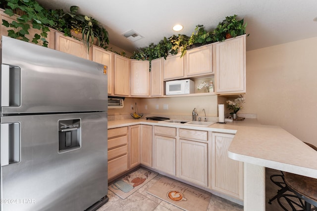 kitchen with sink, light brown cabinets, stainless steel fridge, and kitchen peninsula