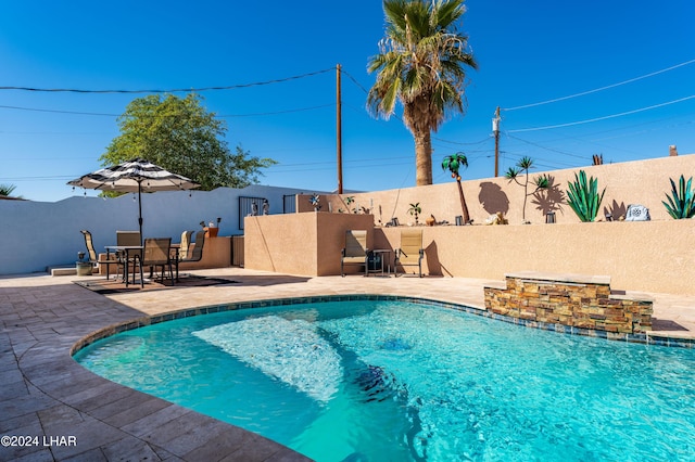 view of swimming pool featuring pool water feature and a patio area