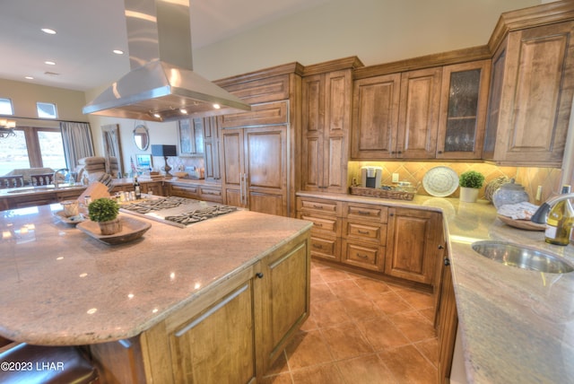 9124 Lakeview Dr, Parker, AZ 85344 - kitchen with sink, decorative backsplash, island exhaust hood, light stone countertops, and a spacious island