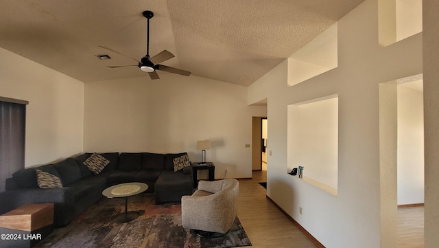 living room featuring ceiling fan, hardwood / wood-style flooring, vaulted ceiling, and a textured ceiling