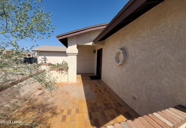 view of exterior entry featuring a patio