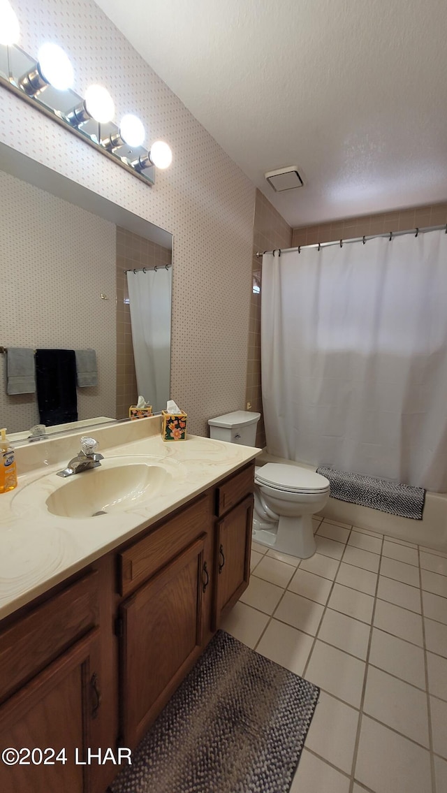 bathroom with vanity, a textured ceiling, tile patterned floors, and toilet