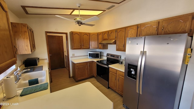 kitchen with lofted ceiling, sink, light hardwood / wood-style flooring, appliances with stainless steel finishes, and ceiling fan