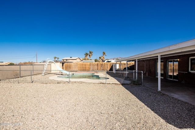 view of yard with an empty pool and a patio
