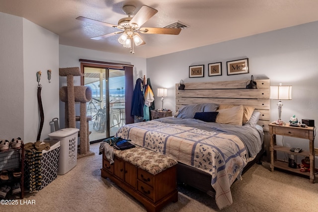 bedroom with access to exterior, visible vents, light carpet, and a ceiling fan