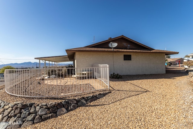 back of house featuring a patio area, a mountain view, and stucco siding