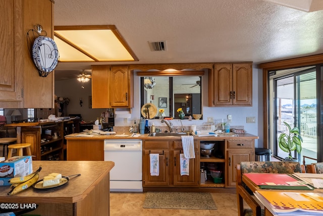 kitchen featuring visible vents, ceiling fan, a sink, light countertops, and dishwasher