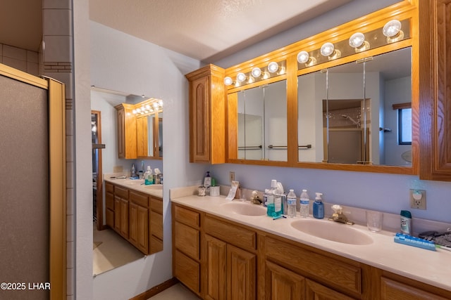 full bathroom featuring double vanity, a stall shower, and a sink