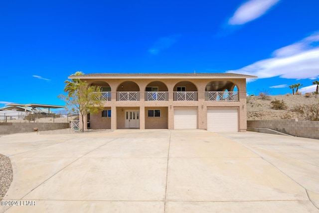 view of front of home with a garage and a balcony