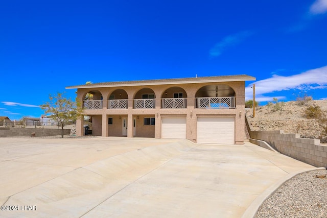 view of front of house with a garage, a balcony, and ceiling fan