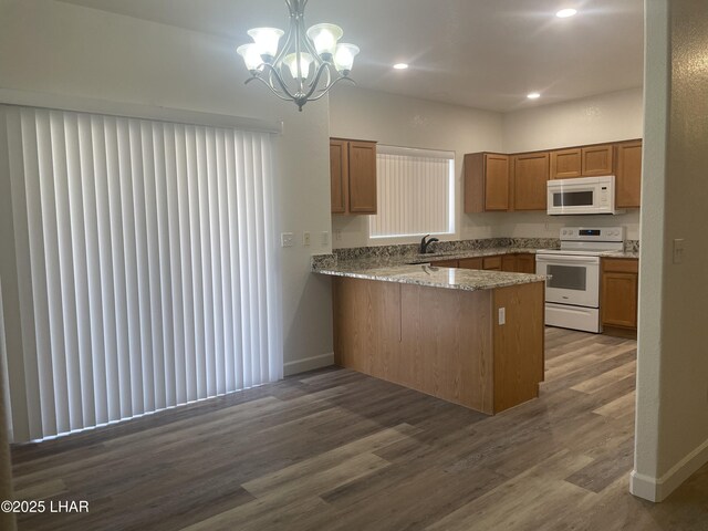 1990 Folzman Dr, Lake Havasu City, AZ 86404 - kitchen featuring white appliances, a peninsula, dark wood-style flooring, brown cabinetry, and a chandelier