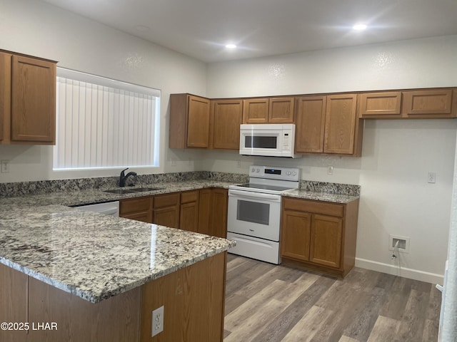 1990 Folzman Dr, Lake Havasu City, AZ 86404 - kitchen featuring white appliances, brown cabinetry, a peninsula, light stone countertops, and recessed lighting