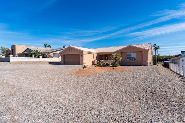 ranch-style house with a garage, driveway, a tile roof, fence, and stucco siding