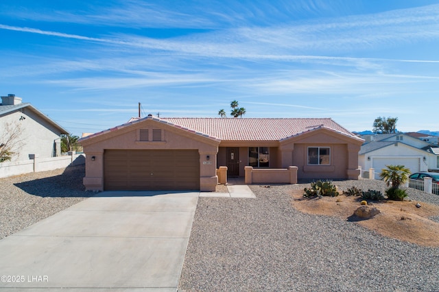 ranch-style home with concrete driveway, a tile roof, an attached garage, fence, and stucco siding