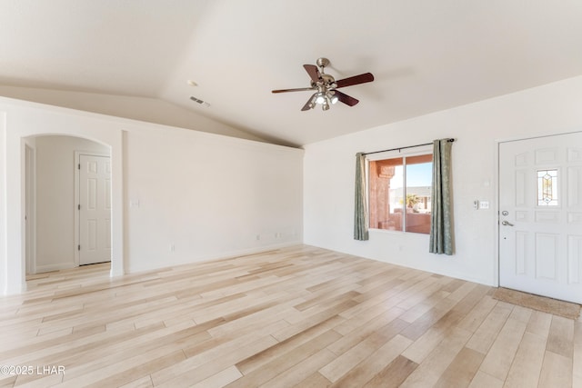 interior space featuring visible vents, arched walkways, a ceiling fan, vaulted ceiling, and light wood-style floors