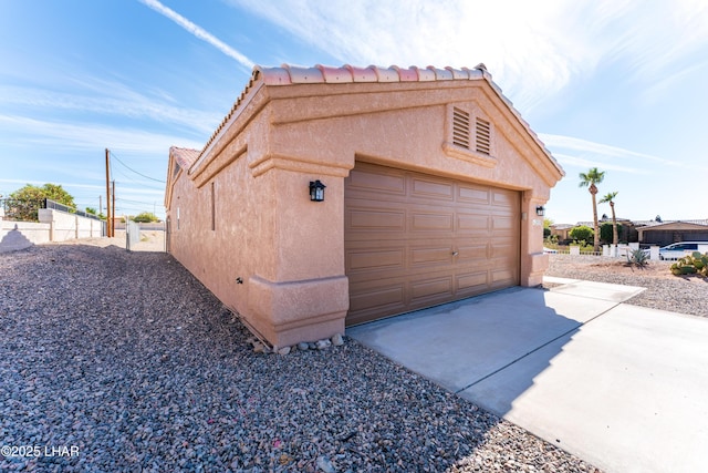 garage with driveway and fence