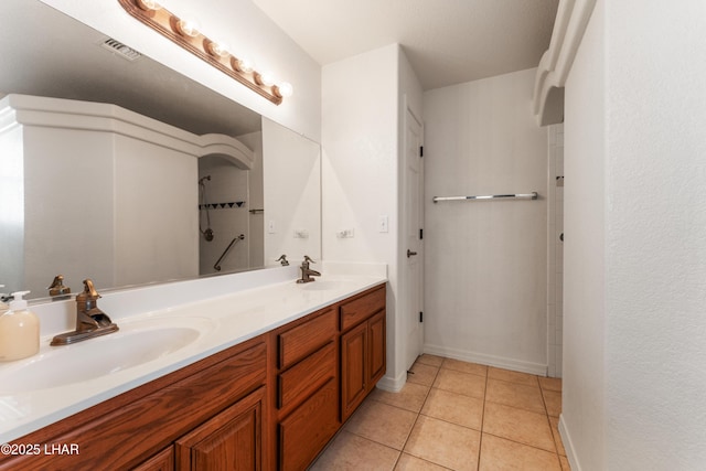 full bathroom featuring double vanity, visible vents, a sink, and tile patterned floors