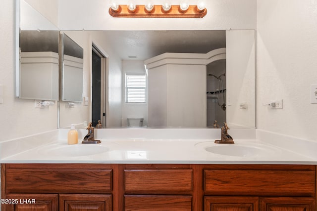 full bath featuring double vanity, toilet, and a sink