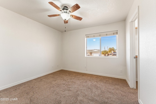 carpeted spare room with ceiling fan, a textured ceiling, and baseboards