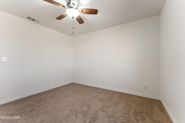 carpeted spare room with visible vents, ceiling fan, and baseboards