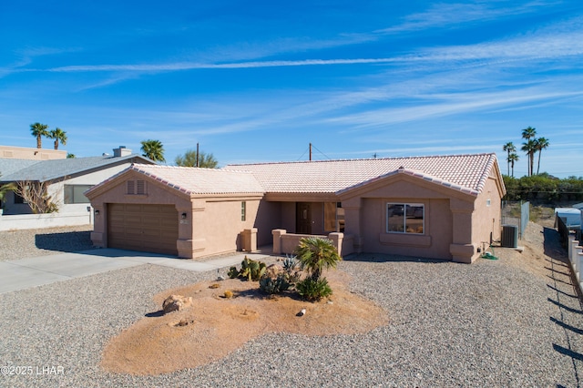 single story home with a garage, concrete driveway, a tiled roof, and stucco siding