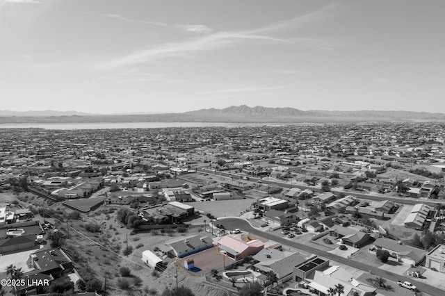 drone / aerial view featuring a water and mountain view and a residential view