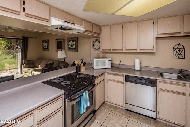 kitchen featuring sink, a textured ceiling, light brown cabinets, light tile patterned floors, and appliances with stainless steel finishes