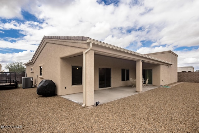 back of house featuring stucco siding, fence, central AC, and a patio area