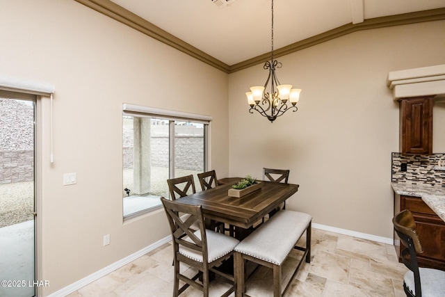 dining area featuring a notable chandelier, plenty of natural light, baseboards, and ornamental molding