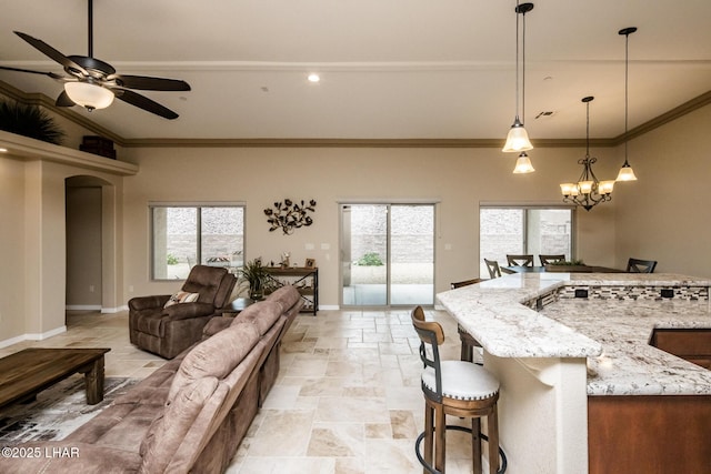 kitchen featuring ceiling fan with notable chandelier, baseboards, and a healthy amount of sunlight