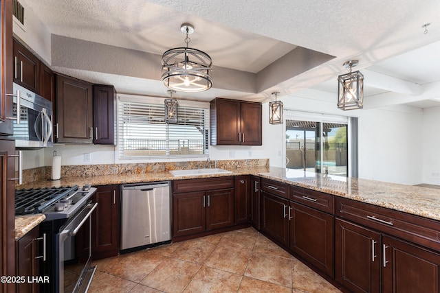 kitchen with a chandelier, appliances with stainless steel finishes, a sink, and a wealth of natural light