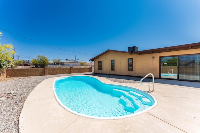 view of pool featuring a patio area, a fenced backyard, and central AC