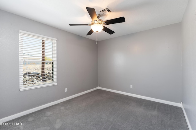 empty room featuring dark carpet, ceiling fan, baseboards, and visible vents