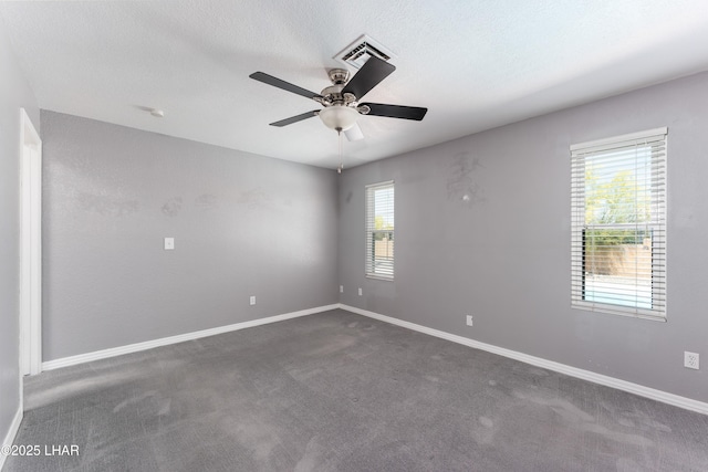 carpeted spare room featuring visible vents, baseboards, and a ceiling fan