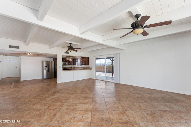 unfurnished living room featuring baseboards, a ceiling fan, visible vents, beam ceiling, and stone finish flooring