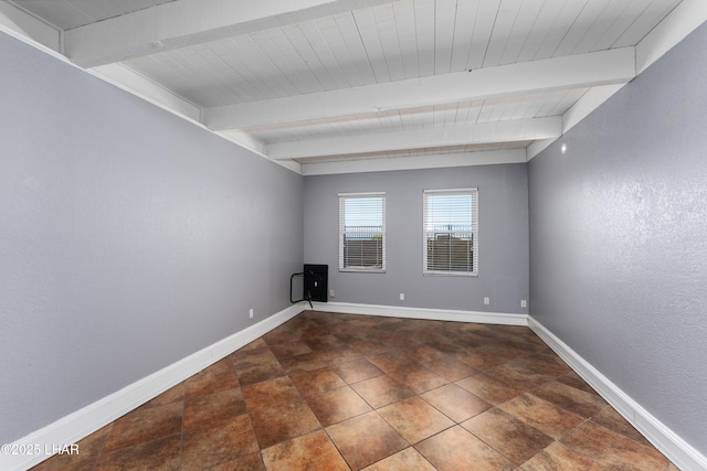 unfurnished room featuring beam ceiling and baseboards