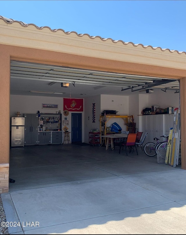 garage featuring a garage door opener and stainless steel fridge