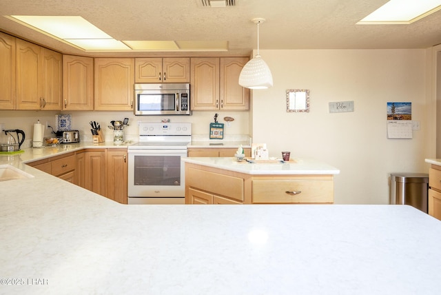 kitchen featuring white electric stove, light brown cabinetry, stainless steel microwave, and light countertops