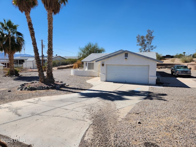 view of front of home featuring a garage, driveway, and stucco siding