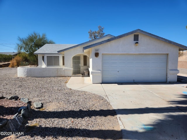 ranch-style home featuring a garage, concrete driveway, and stucco siding